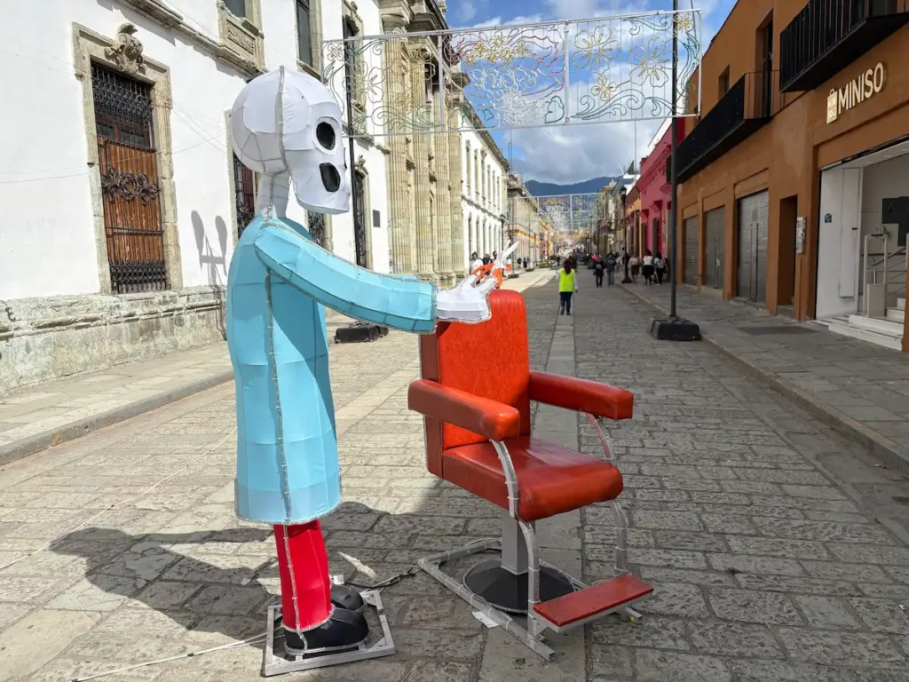 Oaxaca City Day of the Dead street decorations - Catrina Barber cutting hair with chair