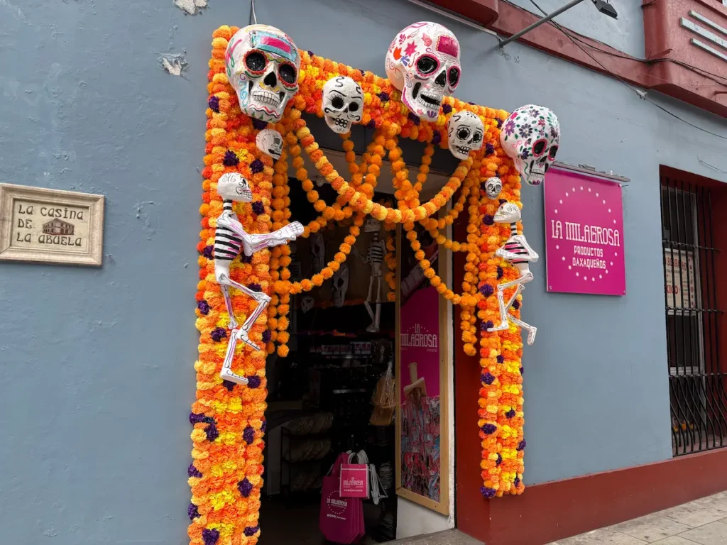 Oaxaca City Day of the Dead street decorations - Shop front with skulls and flowers